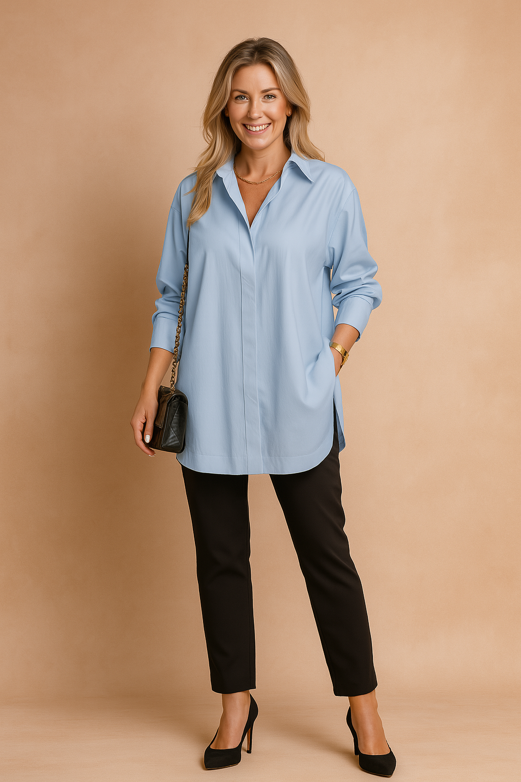 Oversized light blue collared blouse with long sleeves and a clean concealed button placket, styled with slim-fit black trousers and a quilted black chain-strap handbag.