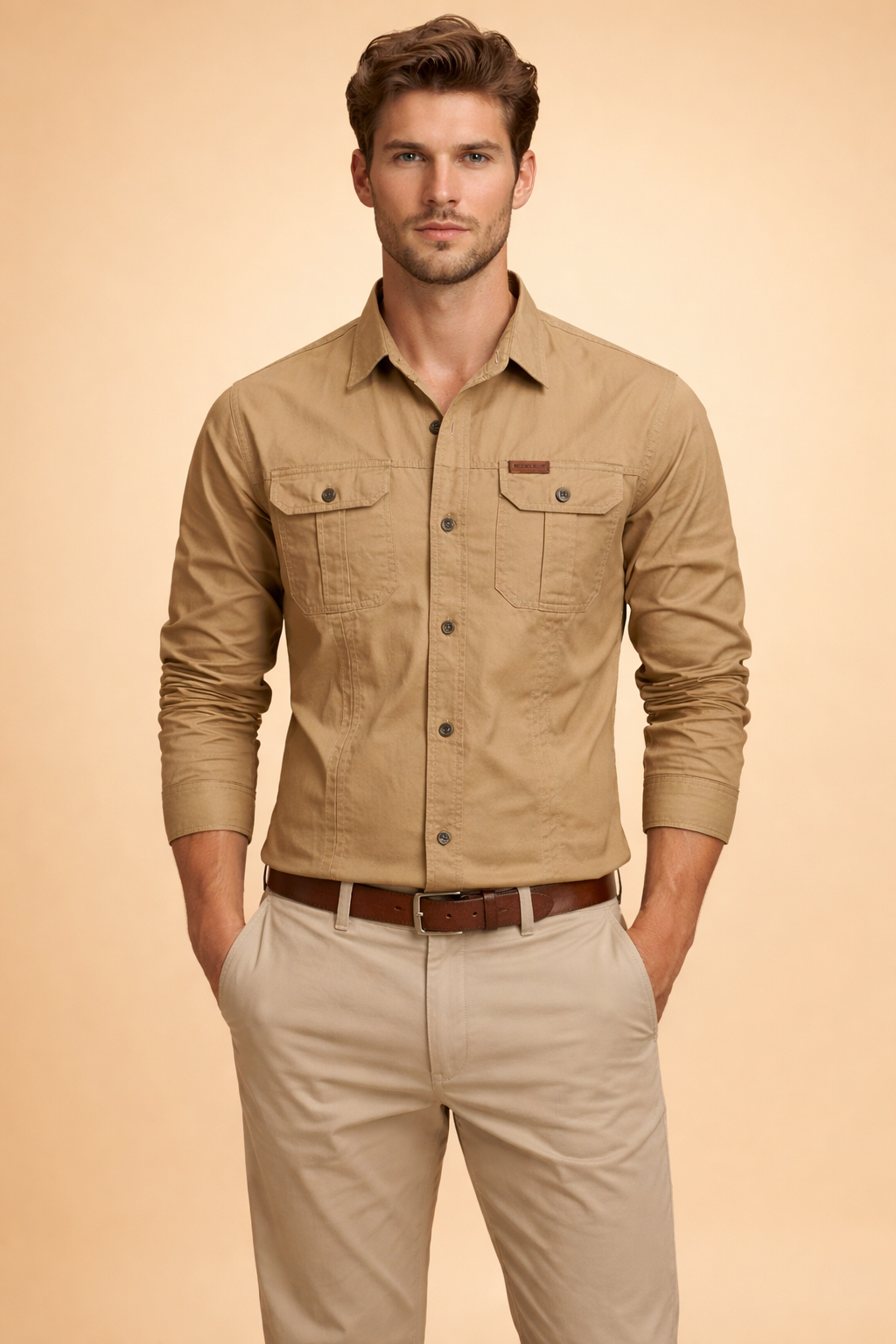 Long-sleeve utility button-up shirt with chest flap pockets, structured seams, and a clean front closure, styled with straight-leg tailored trousers and a classic leather belt