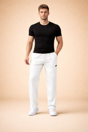Men’s white tailored jogger-style trousers with a straight leg cut, elastic waistband with drawstring, clean front seams, minimal branding detail, and paired with low-profile white sneakers for a modern casual look.
