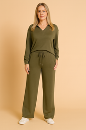 Two-piece army green loungewear set featuring a long-sleeve V-neck top with a collar detail and matching wide-leg drawstring pants, styled with white sneakers.