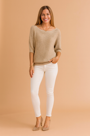 Light beige knit pullover with a wide neckline, half sleeves, ribbed cuffs and hem, styled with white skinny jeans and taupe suede heels.