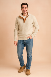 Beige ribbed pullover sweater with brown button placket and suede elbow patches, paired with casual blue jeans and tan shoes, styled for a smart-casual look