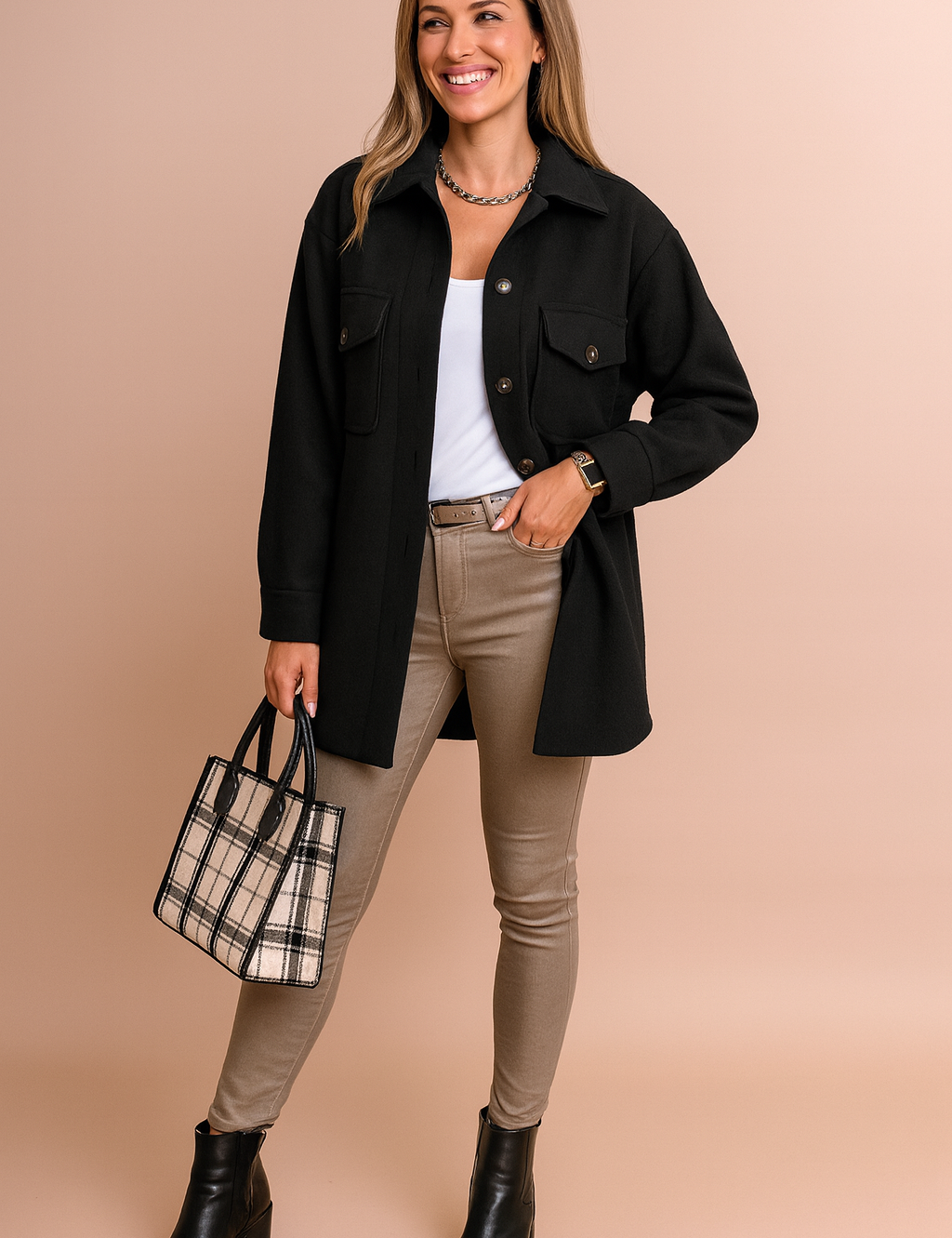 Black button-up jacket with flap chest pockets and matching buttons, styled over a white top, beige slim-fit pants, black ankle boots, and a plaid tote bag.