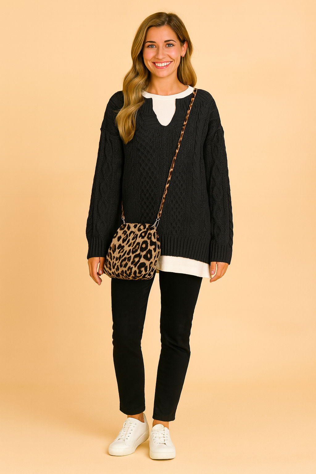 Oversized sweater with classic cable pattern, paired with a white inner shirt, slim black pants, white sneakers, and a leopard-print shoulder bag