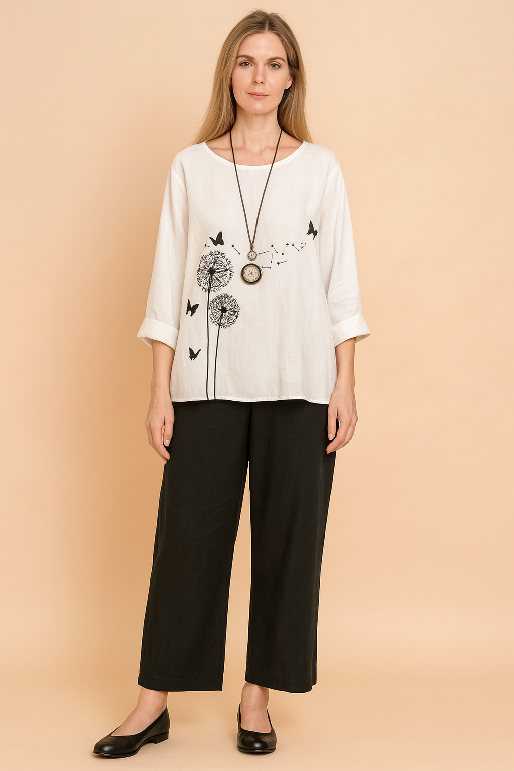 White linen three-quarter sleeve blouse with black dandelion and butterfly print, paired with black straight-leg ankle-length pants made of soft, flowy fabric.