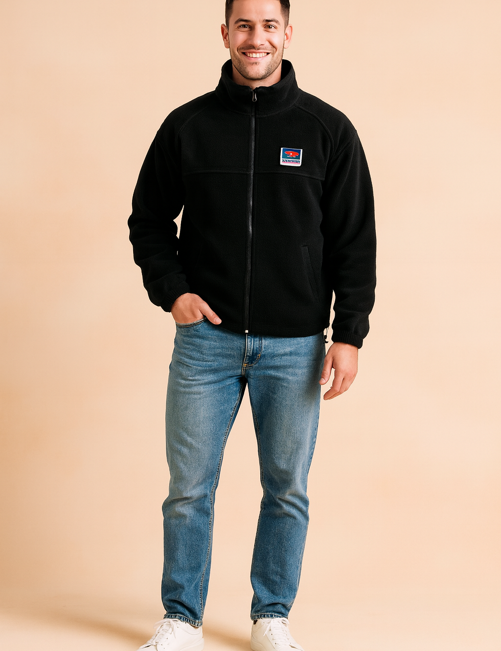 Black fleece zip-up jacket with a high collar, chest logo patch, and front pockets, styled casually with jeans and sneakers for a modern outdoor look.
