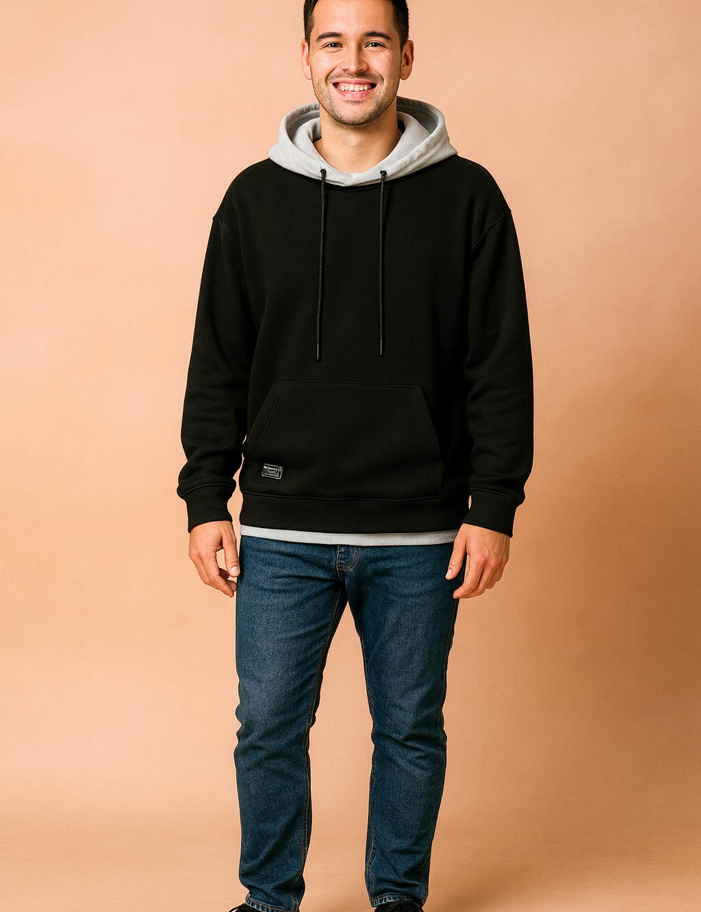 Men’s casual black hoodie with light gray hood lining, paired with blue slim-fit jeans and black sneakers.