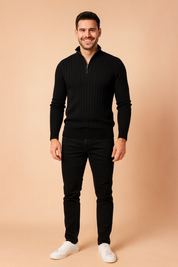 Men’s black ribbed half-zip sweater with vertical textured patterns, styled with slim-fit black jeans and white sneakers.