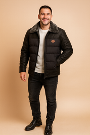 Black puffer and sherpa jacket with faux fur collar, front zipper, and quilted details, paired with casual dark jeans and leather boots.