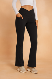 Black V-waist yoga pants with a slight bootcut flare, side pockets, and contour stitching, crafted from a smooth stretch fabric for a sculpted fit.