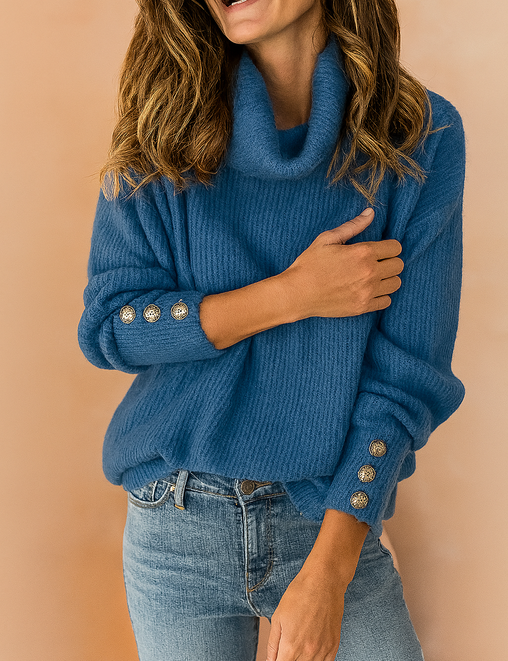 Blue ribbed knit cowl-neck sweater with decorative gold-tone buttons on the sleeves, styled with mid-rise blue denim jeans.