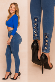 High-waisted blue denim jeggings with button detailing along the ankle, styled with a vibrant blue cropped top and black stiletto heels. The jeggings feature a slim fit cut with precise stitching and a smooth, form-flattering finish.