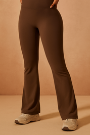 High-waisted chocolate brown flared leggings with a smooth, fitted silhouette and subtle stretch, styled with off-white athletic sneakers.