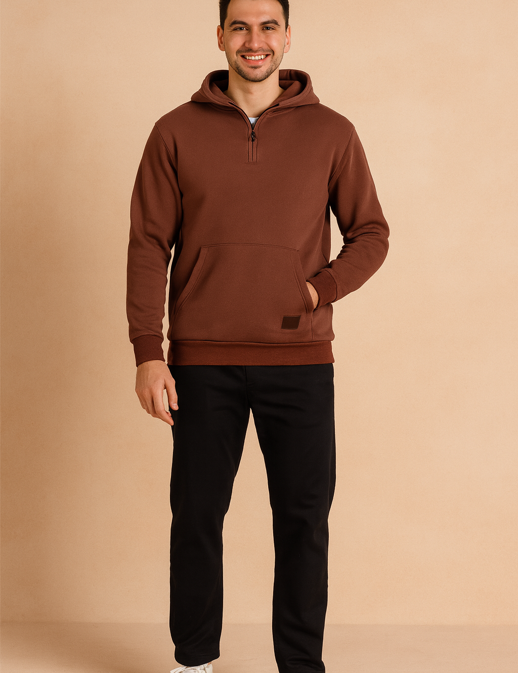 Brown half-zip hoodie with kangaroo pocket, ribbed cuffs, and hem, styled with black pants and white sneakers for a relaxed casual look.