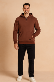 Brown half-zip hoodie with kangaroo pocket, ribbed cuffs, and hem, styled with black pants and white sneakers for a relaxed casual look.