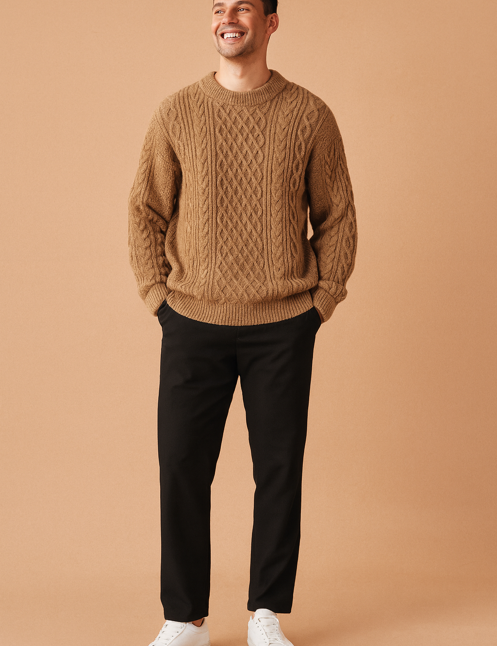 Men’s camel brown cable knit sweater with intricate diamond and braided patterns, classic crew neckline, ribbed cuffs and hem, paired with black straight-leg pants and white sneakers.