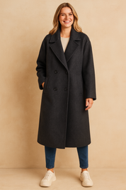 Charcoal gray double-breasted long coat with wide lapel collar and front welt pockets, styled for a timeless winter look.
