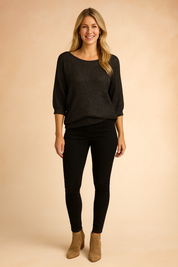 Dark charcoal knit top with elbow-length sleeves, relaxed ribbed hem, and scoop neckline, paired with black skinny pants and tan ankle boots.