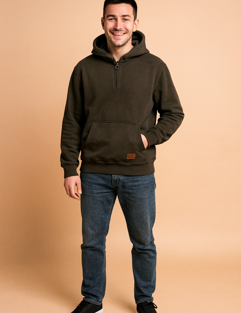 Dark charcoal half-zip hoodie with front kangaroo pocket, ribbed cuffs, and hem, paired with casual jeans for a relaxed streetwear look.