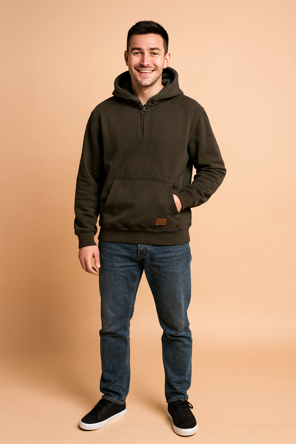 Dark charcoal half-zip hoodie with front kangaroo pocket, ribbed cuffs, and hem, paired with casual jeans for a relaxed streetwear look.