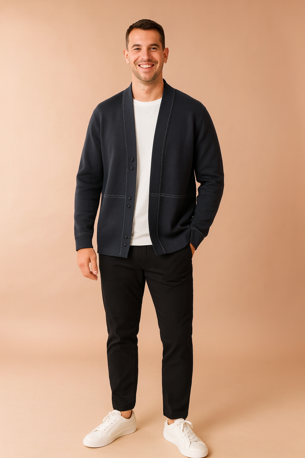 Dark gray open-front cardigan with white stitched detailing, styled over a white T-shirt, slim black trousers, and white sneakers for a modern casual look.
