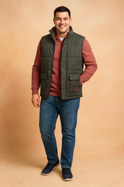 Dark green padded winter vest with front buttoned pockets and warm brown fur lining, styled over a casual long-sleeve top for outdoor comfort.