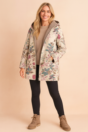 Floral print hooded winter jacket with soft fleece lining, tailored in a relaxed fit for warmth and comfort, featuring a beige base with vibrant pink and green botanical patterns.