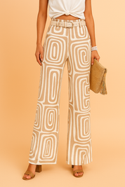High-waisted wide-leg pants with bold cream and tan geometric swirl print, detailed with front belt loops and a matching belt for a tailored yet relaxed fit.