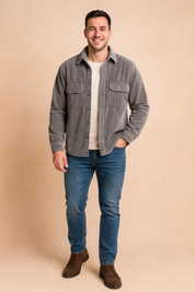 Corduroy sherpa-lined overshirt in gray with vertical ribbed texture, dual chest flap pockets with buttons, rolled cuffs, and exposed warm beige fleece interior, styled for a casual winter look.