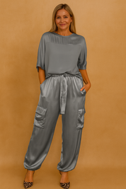 Satin two-piece set featuring a loose-fit short-sleeve top and high-waisted drawstring cargo pants with flap pockets, styled with leopard-print stiletto heels for a sleek, elevated look.