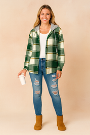Green and white plaid hooded jacket with mustard accents, button closure, and side pockets, styled casually with ripped jeans.