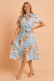 Button-down short-sleeve light blue midi dress with a peach and coral floral print, featuring a belted waist and front slit detail.