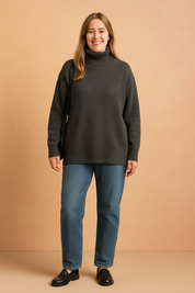 Oversized charcoal gray turtleneck sweater in soft knit with ribbed cuffs and hem, paired with mid-wash straight-leg jeans and black leather loafers.