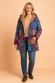 Multicolor patchwork hooded coat featuring bold tribal and floral patterns, fully lined with soft tan faux fur, designed with long sleeves and an open front cut.
