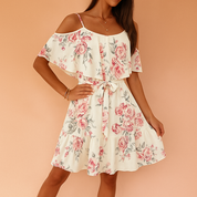 Cream off-shoulder floral dress with pink rose print, ruffle overlay, tiered hem, and waist tie, perfect for summer elegance.