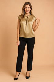 Elegant gold satin blouse with a gathered neckline and cap sleeves, styled with slim-fit black trousers and classic black heels.