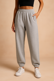 Heather gray high-waisted jogger sweatpants with an elastic waistband and ankle cuffs, styled with white sneakers for a casual loungewear look.