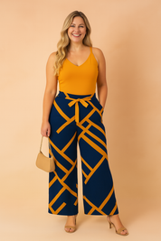 Sleeveless mustard top paired with high-waisted navy wide-leg pants featuring bold mustard geometric stripes and a centered mustard waist tie.