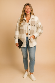 Plaid fleece button-up jacket in cream and taupe, featuring two chest flap pockets and a relaxed oversized fit, paired with light-wash slim jeans and white sneakers.
