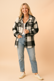 Black and white sherpa plaid button-up jacket with chest pockets, paired with a white tank top and high-waisted light wash jeans.