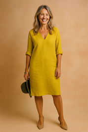 Mustard yellow knee-length dress with a soft V-neckline and rolled 3/4 sleeves, crafted in lightweight linen with a relaxed fit for a casual-chic silhouette.