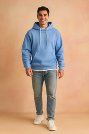 Men’s light blue pullover hoodie with front kangaroo pocket and white drawstrings, styled with light blue jeans and white sneakers.
