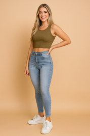 Light blue high-waisted skinny jeggings with a faded wash, ankle-length slim fit, styled with white sneakers for a modern casual look.