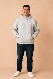 Light gray oversized hoodie with kangaroo pocket and ribbed cuffs, styled with dark blue jeans and white sneakers for a relaxed casual look.