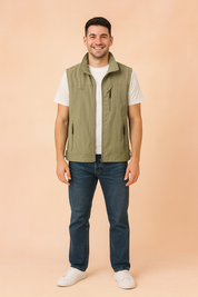 Light khaki sleeveless outdoor vest with zip closure, high collar, and multiple zippered pockets, styled over a white t-shirt.