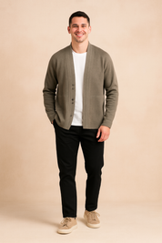 Light olive green men's button-up cardigan with wide shawl collar and subtle horizontal seam detailing; minimalist design with fine contrast stitching and clean front finish over a plain white inner shirt.
