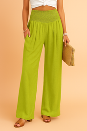 Wide-leg linen pants in bright lime green featuring a pleated front, smocked high-rise waistband, and soft, breathable fabric with a flowy silhouette.
