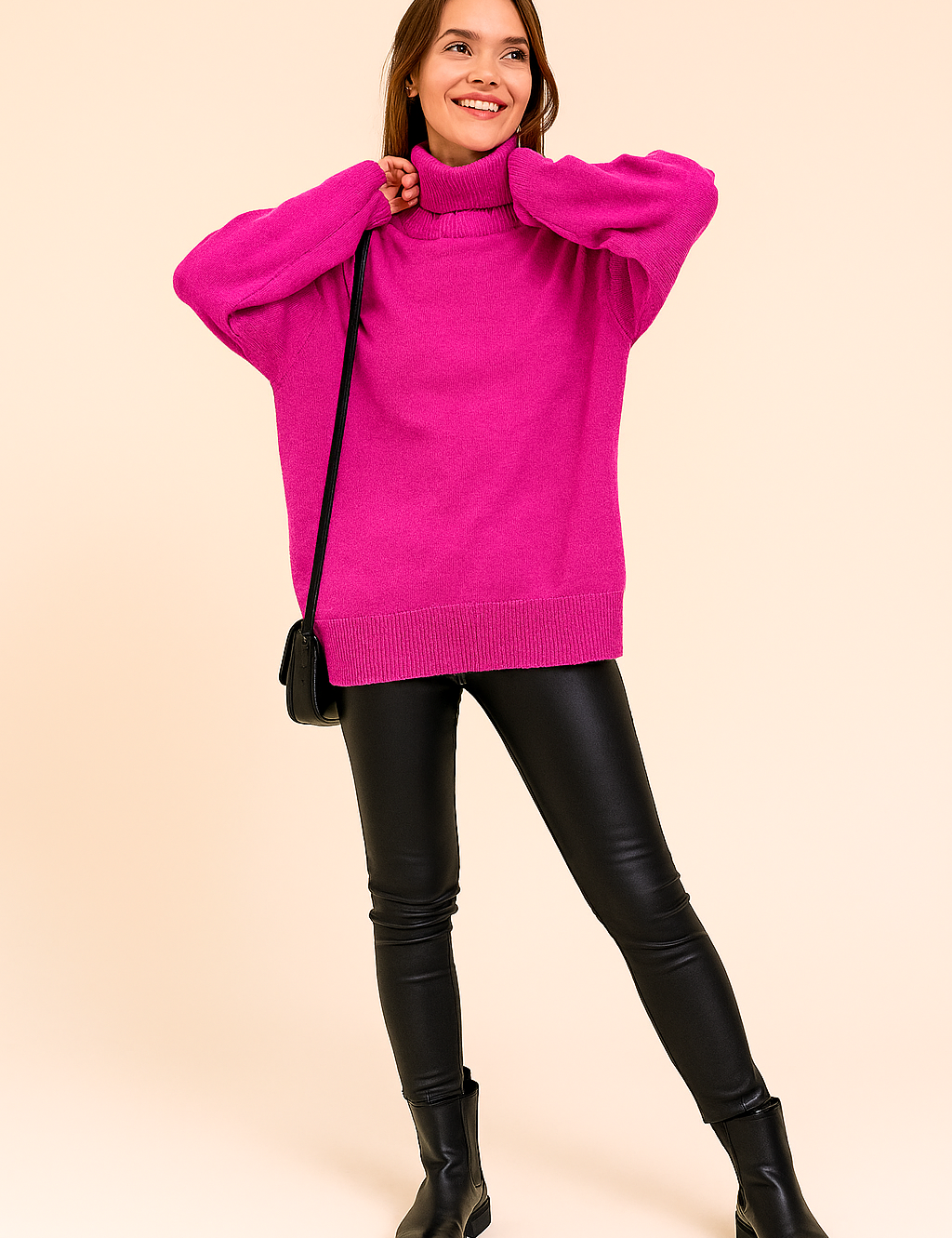 Vibrant magenta oversized knit turtleneck sweater paired with black faux leather leggings, styled with black ankle boots and a minimalist shoulder bag