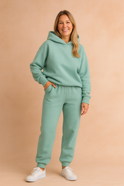 Mint green fleece coord set with an oversized hooded sweatshirt featuring drop shoulders and ribbed cuffs, paired with high-waisted jogger pants in matching fabric and tapered ankles.

