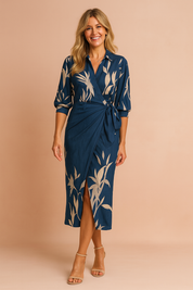 Navy blue botanical wrap dress with beige floral print, three-quarter sleeves, shirt collar, waist tie, and front slit detail in a midi-length silhouette.